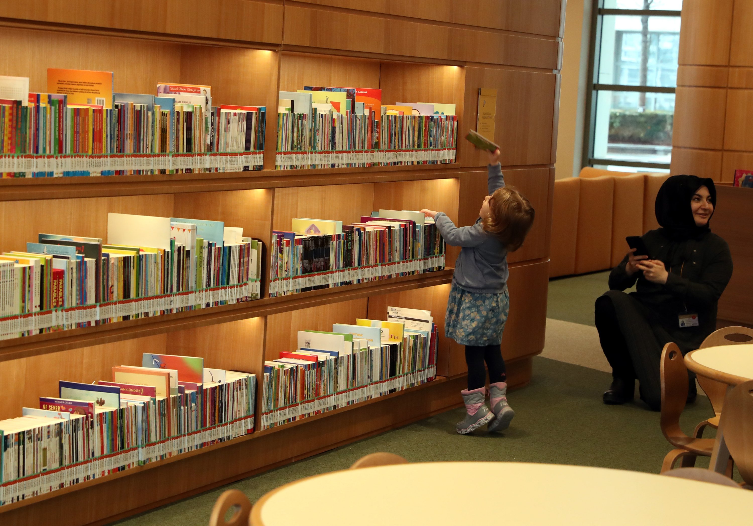 A little child takes a book from a shelf at the Presidential Library, Ankara, Turkey, Feb. 21, 2020. (Photo by Ali Ekeyılmaz) 