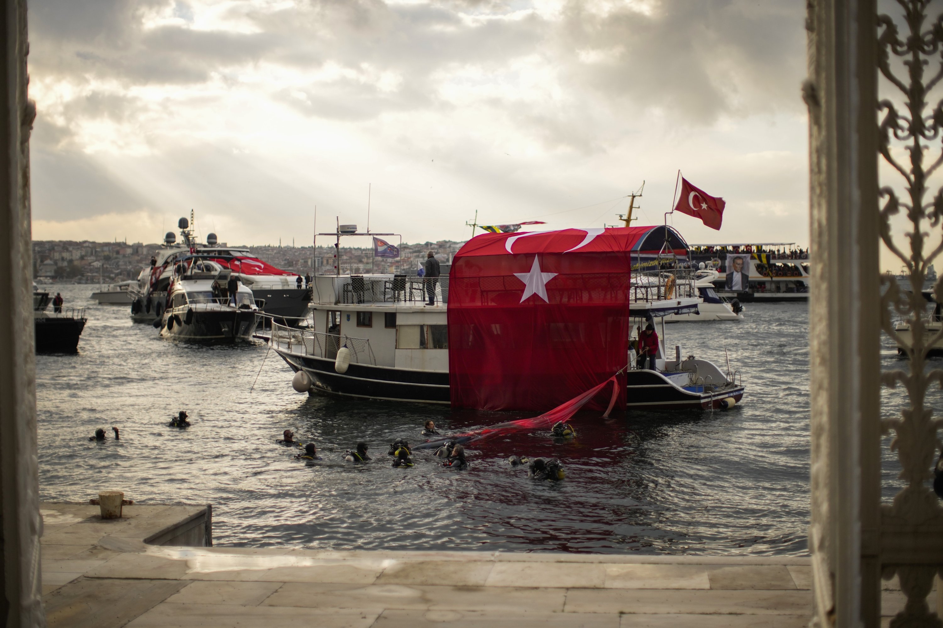 Bendera Turki dipajang di atas kapal saat orang-orang memberikan penghormatan untuk menandai peringatan ke-83 Turki