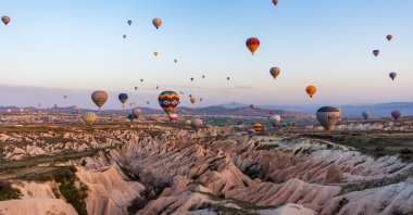 Hot air balloons dot the sky in Cappadocia, Turkey. (Shutterstock Photo)