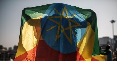 A man covers himself with an Ethiopian flag during a rally in support of the national defense forces, Addis Ababa, Ethiopia, Nov. 7, 2021. (AFP Photo)