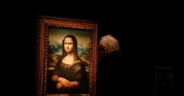 A visitor looks at the copy of Leonardo da Vinci's "Mona Lisa" at the Artcurial auction house in Paris, France, Nov. 5, 2021. (REUTERS Photo)