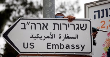 A worker hangs a road sign directing to the U.S. Embassy, in the area of the U.S. Consulate in East Jerusalem, occupied Palestine, May 7, 2018. (Reuters File Photo)