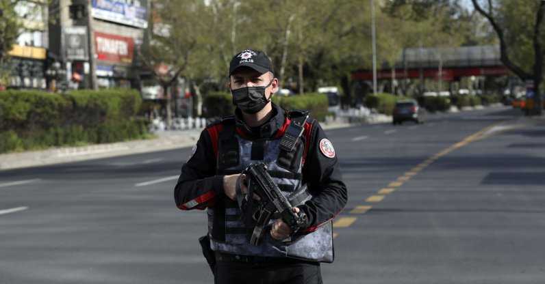 A police officer secures the area on a deserted main road in Ankara, Turkey, Friday, April 30, 2021. (AP File Photo)