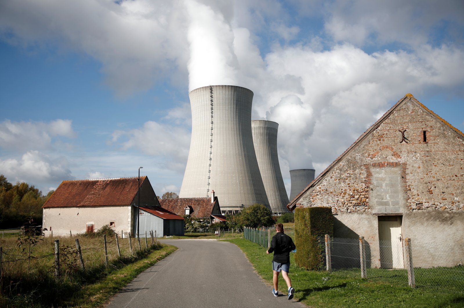 Steam rises from cooling towers of the Electricite de France (EDF) nuclear power plant behind houses in Dampierre-en-Burly, France, Oct. 12, 2021. (Reuters Photo)