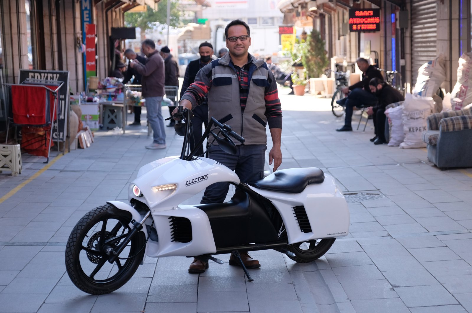 Afghan refugee Mustafa Muhammedi, 37, stands behind his electronic bike that he designed and built, Konya, Turkey, Nov. 8, 2021. (DHA Photo)