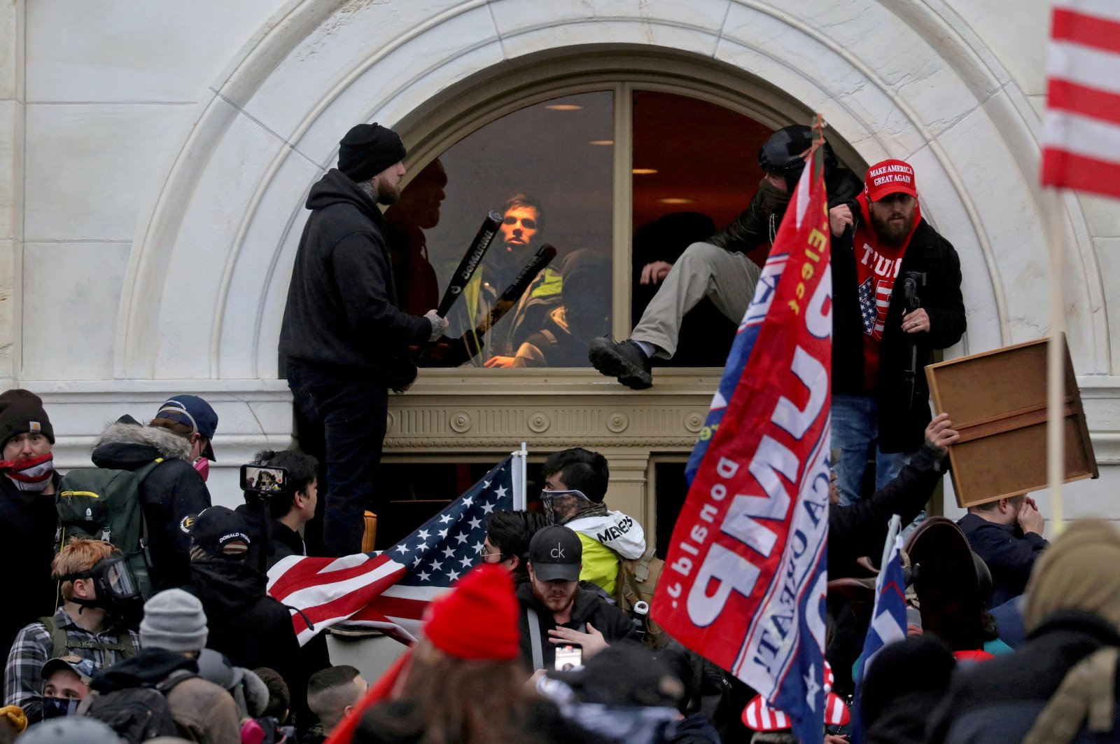 Supporters of then-U.S. President Donald Trump climb through a window they broke as they storm the U.S. Capitol Building in Washington, D.C., U.S., Jan. 6, 2021. (Reuters Photo)