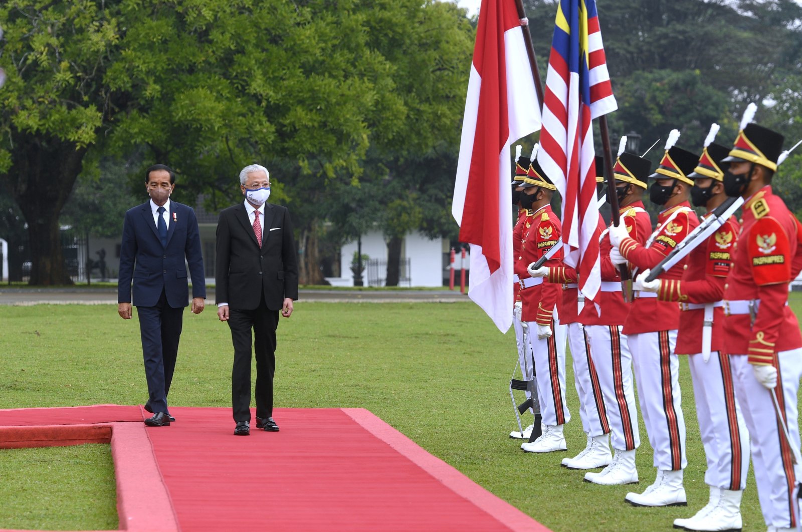 Malaysian Prime Minister Ismail Sabri Yaakob, (C), and Indonesian President Joko Widodo, (L), inspect honor guards during their meeting in Bogor, West Java, Indonesia, Nov. 10, 2021. (AP Photo)
