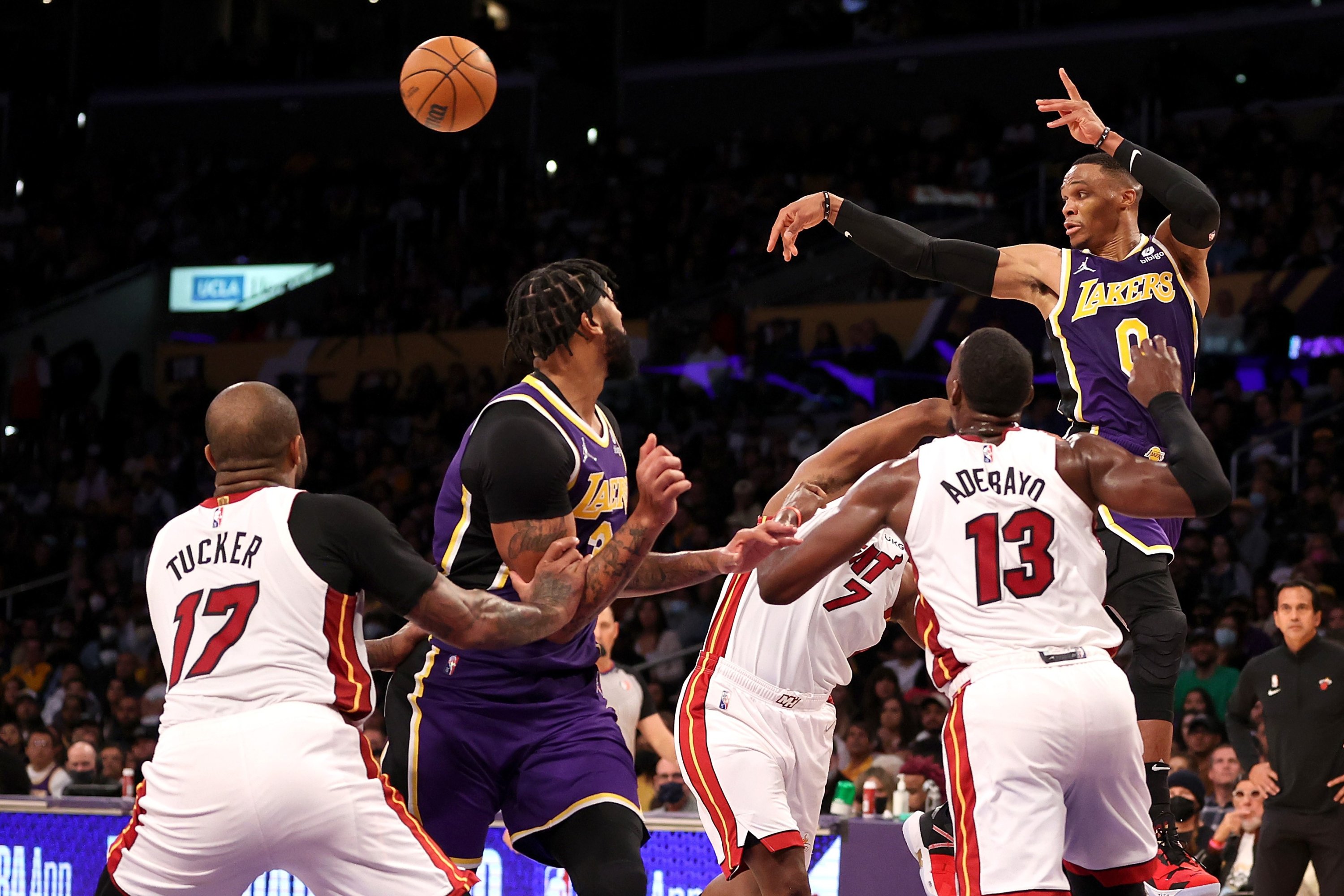 Russell Westbrook dari LA Lakers mengoper bola melewati pemain Miami Heat selama pertandingan NBA di Los Angeles, California, 10 November 2021. (AFP Photo)
