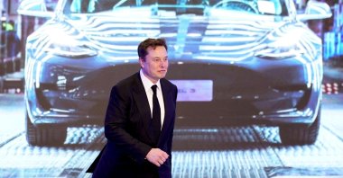 Tesla CEO Elon Musk walks next to a screen showing an image of the Tesla Model 3 car during the opening ceremony of the Tesla China-made Model Y program in Shanghai, China, Jan. 7, 2020. (Reuters Photo)
