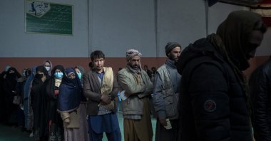 People wait in a line to receive cash at a money distribution organized by the World Food Program (WFP) in Kabul, Afghanistan, Nov. 3, 2021. (AP Photo)