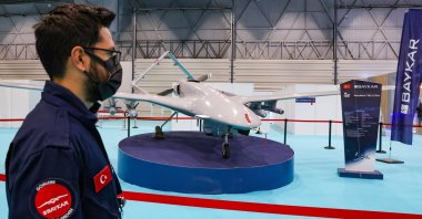 An engineer from Turkish drone-maker Baykar stands next to a TB2 drone during the first day of SAHA EXPO Defence & Aerospace Exhibition in Istanbul, Turkey, Nov. 10, 2021. (Reuters Photo)