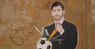 A mural depicting Juventus president Andrea Agnelli making a hole in a football with a knife in Rome, April 22, 2021. (AP Photo)