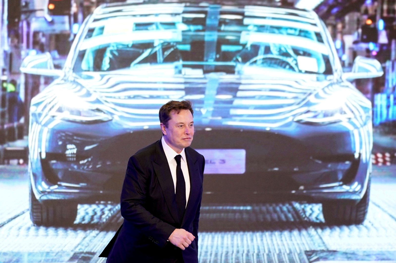 Tesla CEO Elon Musk walks next to a screen showing an image of the Tesla Model 3 car during the opening ceremony of the Tesla China-made Model Y program in Shanghai, China, Jan. 7, 2020. (Reuters Photo)