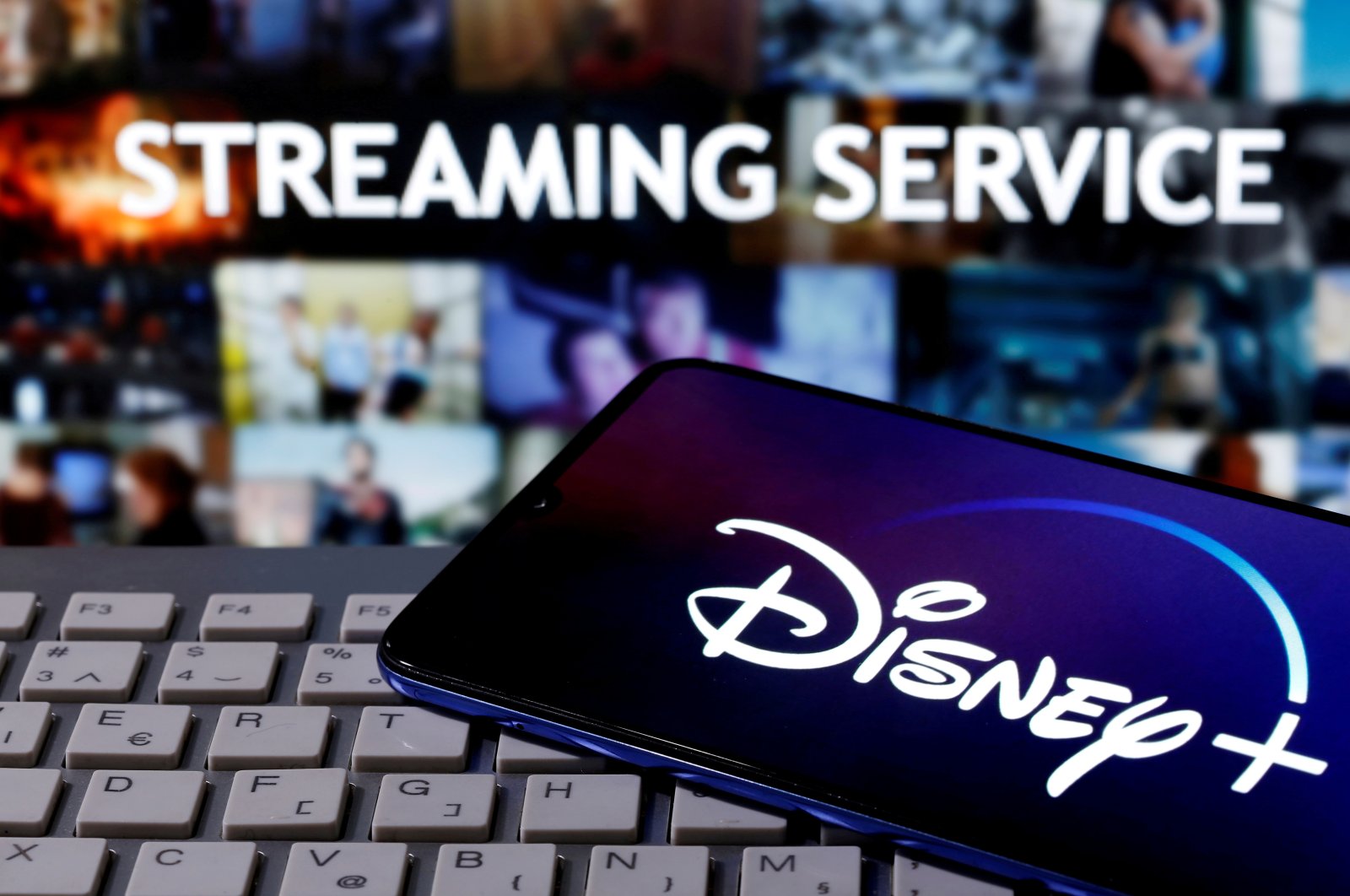 A smartphone with the "Disney" logo is seen on a keyboard in front of the words "Streaming service" in this picture illustration taken March 24, 2020. (REUTERS Photo)