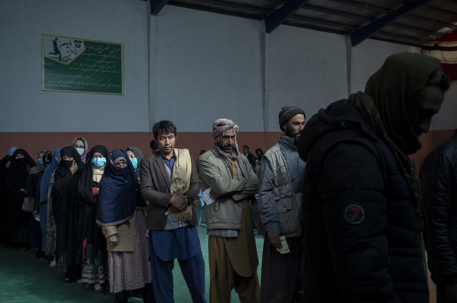 People wait in a line to receive cash at a money distribution organized by the World Food Program (WFP) in Kabul, Afghanistan, Nov. 3, 2021. (AP Photo)