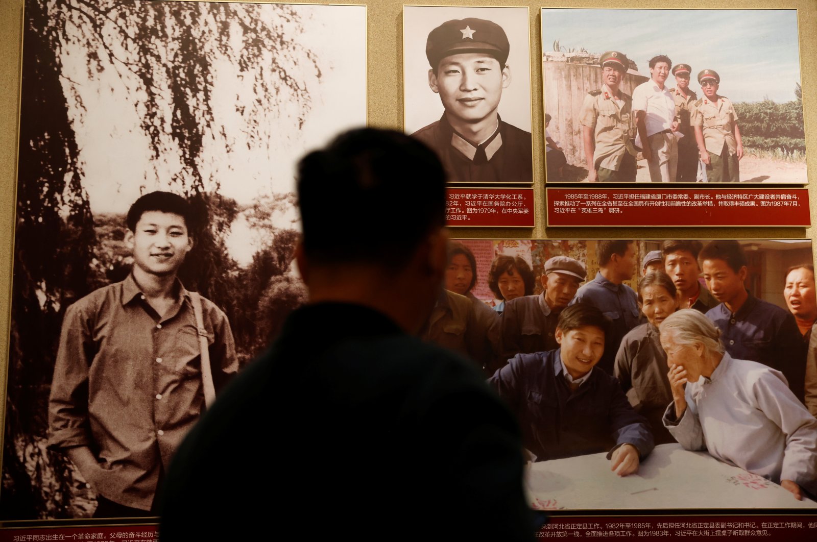 A man stands in front of images of Chinese President Xi Jinping displayed at the Museum of the Communist Party of China in Beijing, China, Nov. 11, 2021. (Reuters Photo)