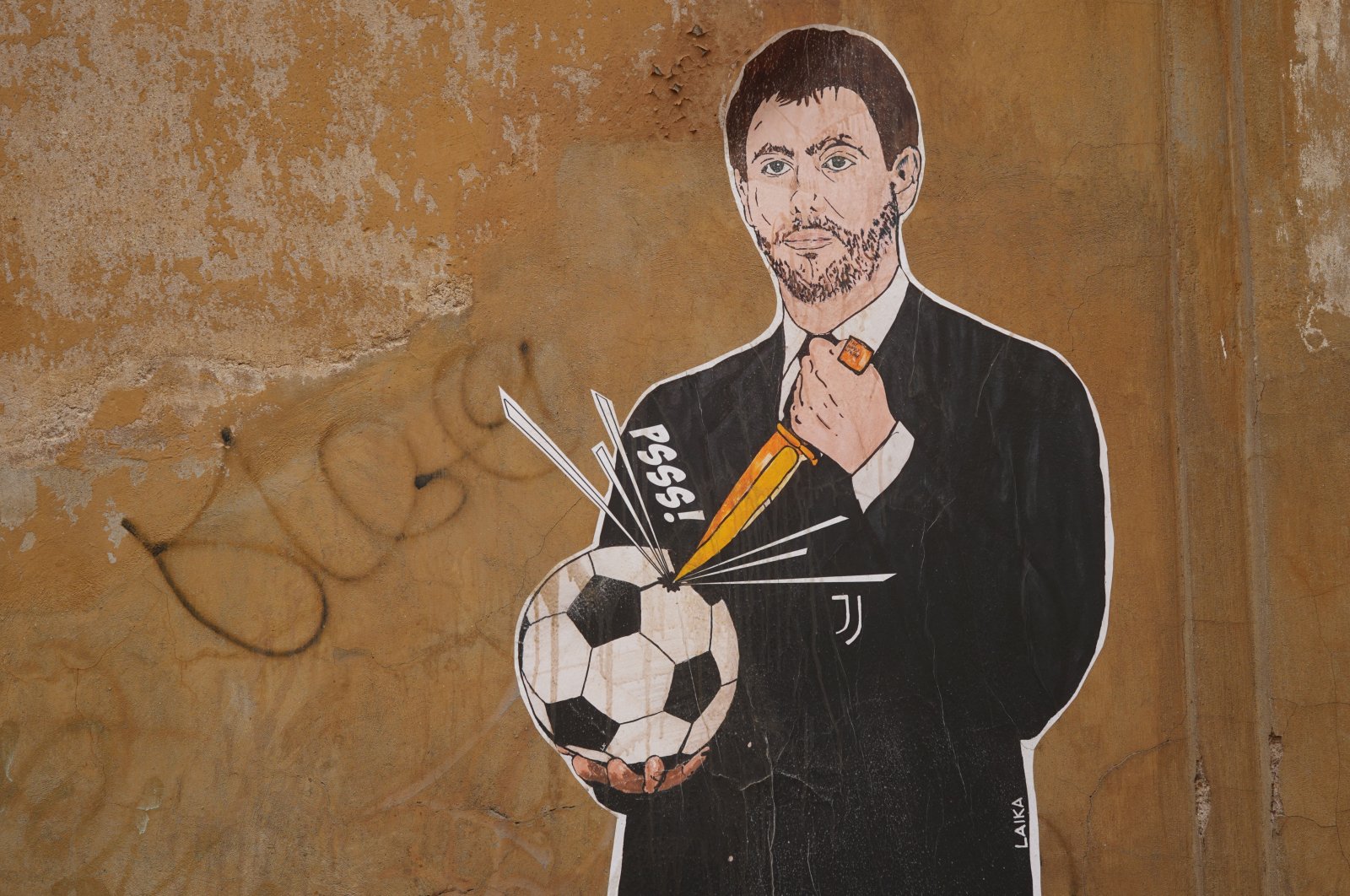 A mural depicting Juventus president Andrea Agnelli making a hole in a football with a knife in Rome, April 22, 2021. (AP Photo)