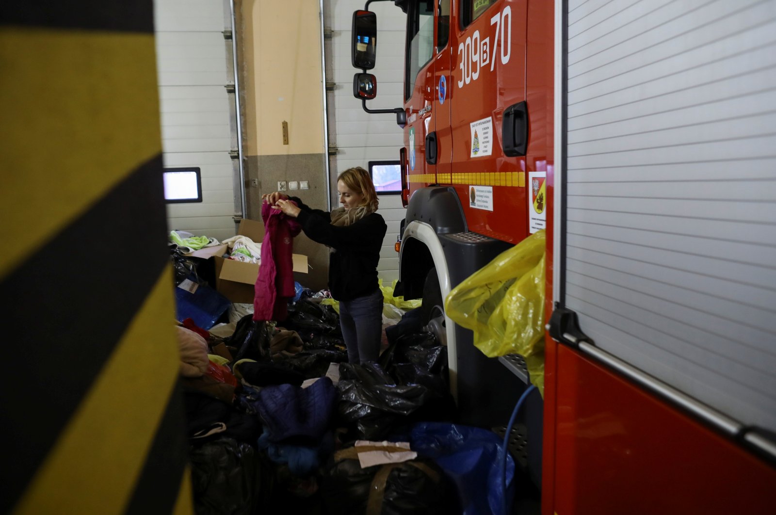 A volunteer sorts clothes for migrants at a fire station that opened its doors for migrants during the migrant crisis on the Belarusian-Polish border, Michalowo, Poland, Nov. 11, 2021. (Reuters Photo)