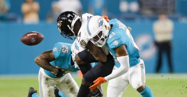 Baltimore Ravens wide receiver Sammy Watkins (14) fumbles the ball after getting tackled by Miami Dolphins cornerback Xavien Howard (25) and free safety Eric Rowe (21) during the fourth quarter at Hard Rock Stadium, Miami Gardens, Florida, U.S., Nov. 11, 2021. (Sam Navarro-USA TODAY Sports via Reuters)