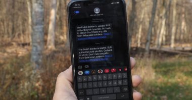 The photographer shows an alert on his smartphone sent by the Polish authorities meant for migrants seeking to enter Poland from Belarus near Hajnowka, Poland, Nov. 11, 2021. (Getty Images)