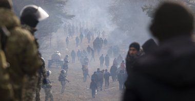 Belarusian officers guard an area as migrants gather at the Belarus-Poland border near Grodno, Belarus, Friday, Nov. 12, 2021. (BelTA pool photo via AP)