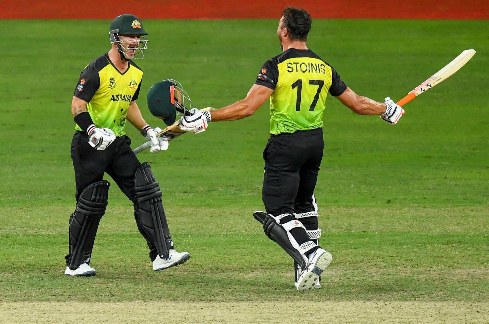 Australia's Marcus Stoinis (R) and Matthew Wade celebrate their victory at the end of the ICC men's T20 World Cup semifinal match against Pakistan in Dubai, UAE, Nov. 11, 2021. (AFP Photo)
