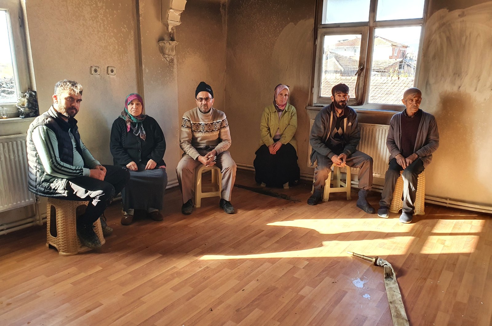Family members sit inside a burned room of their house, in Kastamonu, northern Turkey, Nov. 11, 2021. (IHA PHOTO)