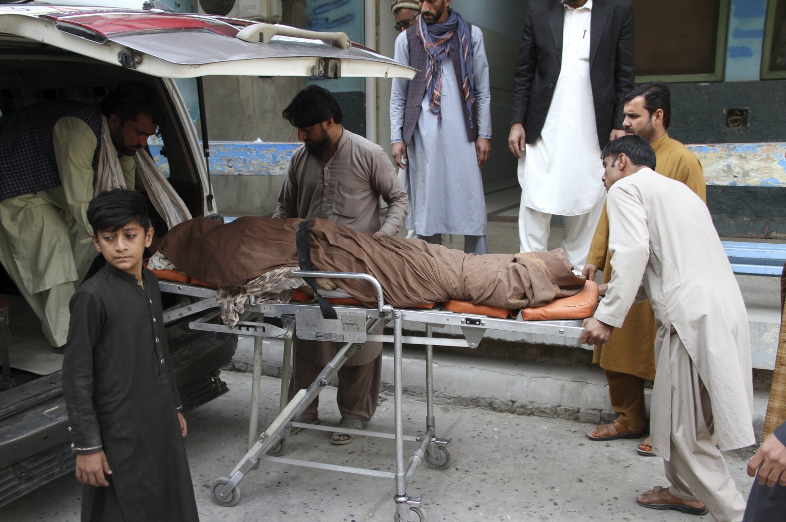 Afghans carry the body of a woman who was killed in a stampede in the city of Jalalabad east of Kabul, Afghanistan, Oct. 21, 2020. (AP Photo)