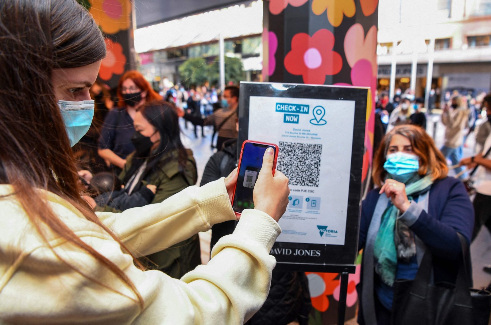 A customer scans a QR code to enter a department store in Melbourne as the city further lifts COVID-19 restrictions allowing nonessential retail shops to open and travel to the regions of Victoria after the city's sixth lockdown, Australia, Oct. 29, 2021. (AFP Photo)
