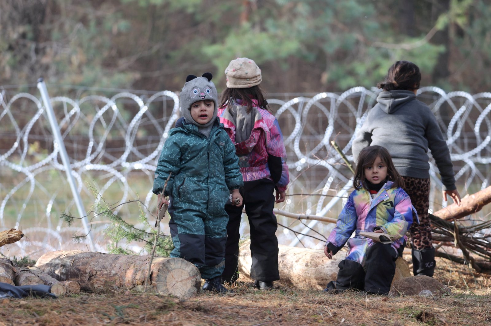 Children gather near a barbed wire fence in a migrants' makeshift camp on the Belarusian-Polish border in the Grodno region, Belarus, Nov. 12, 2021. (Reuters Photo)