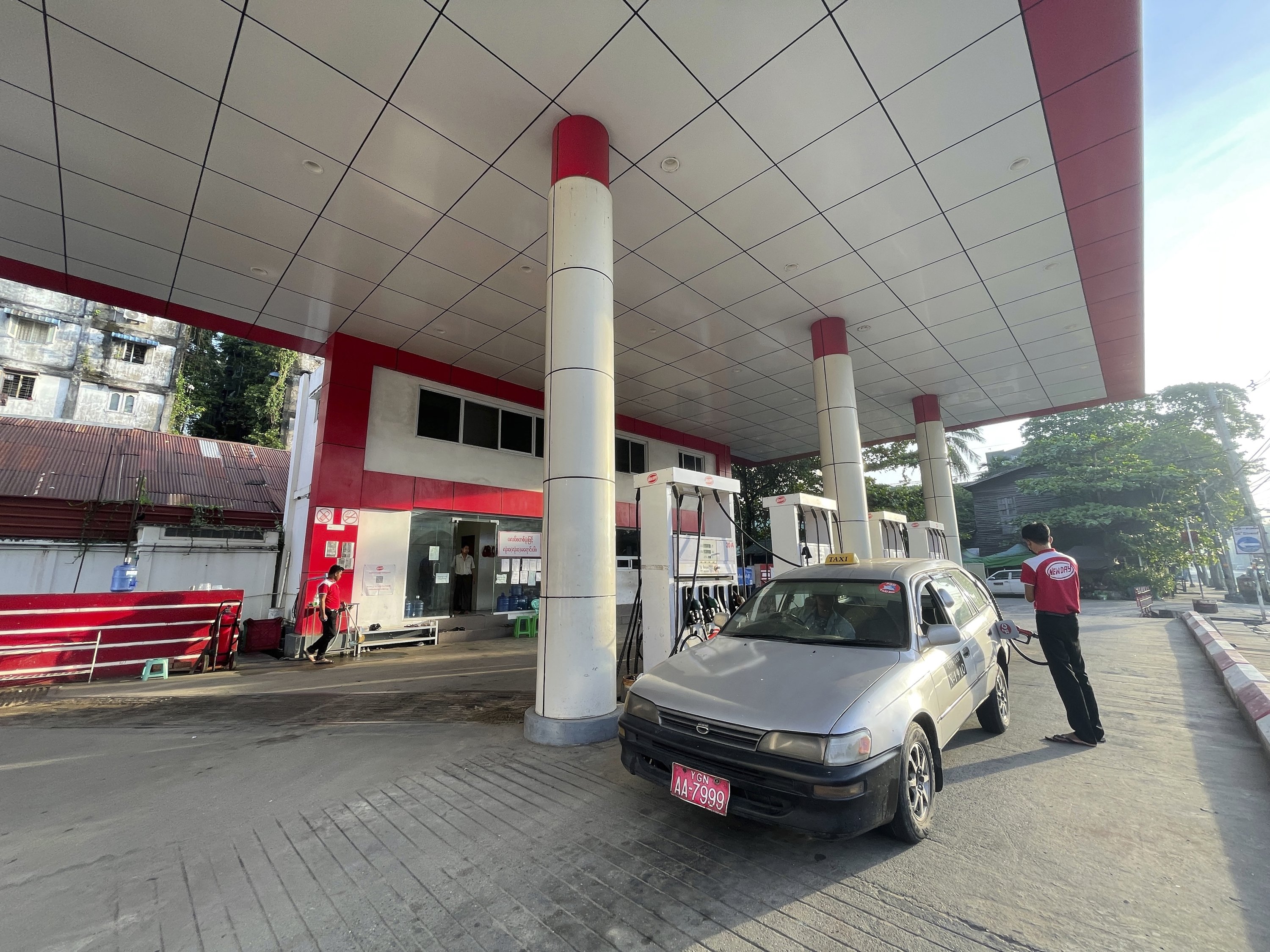 An attendant pumps fuel into a taxi at a gas station in Botahtaung township in Yangon, Myanmar, Nov. 12, 2021. (AP Photo)