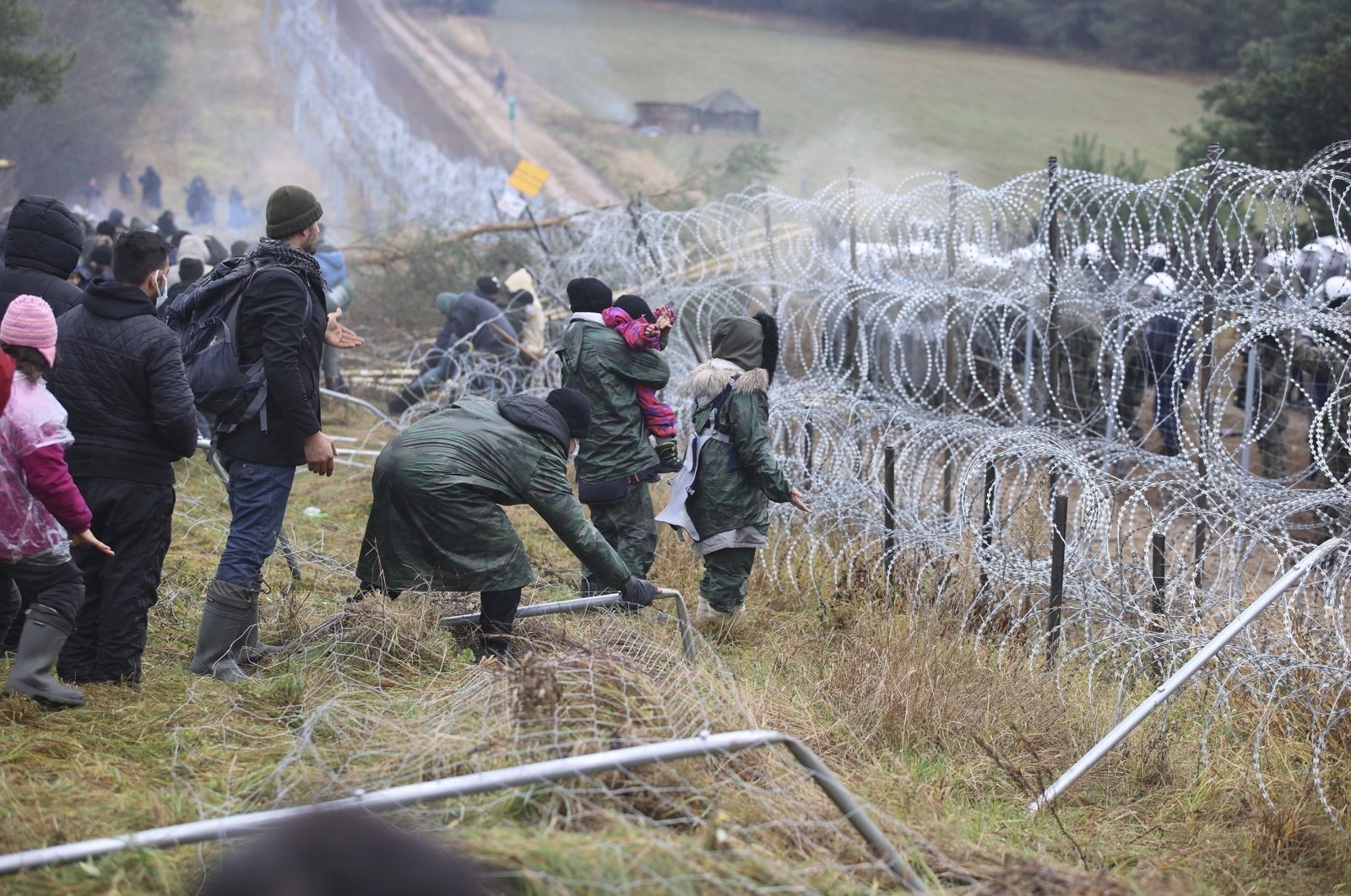 Migrants break down the fence as they gather at the Belarus-Poland border near Grodno, Belarus, Nov. 8, 2021. (AP Photo)