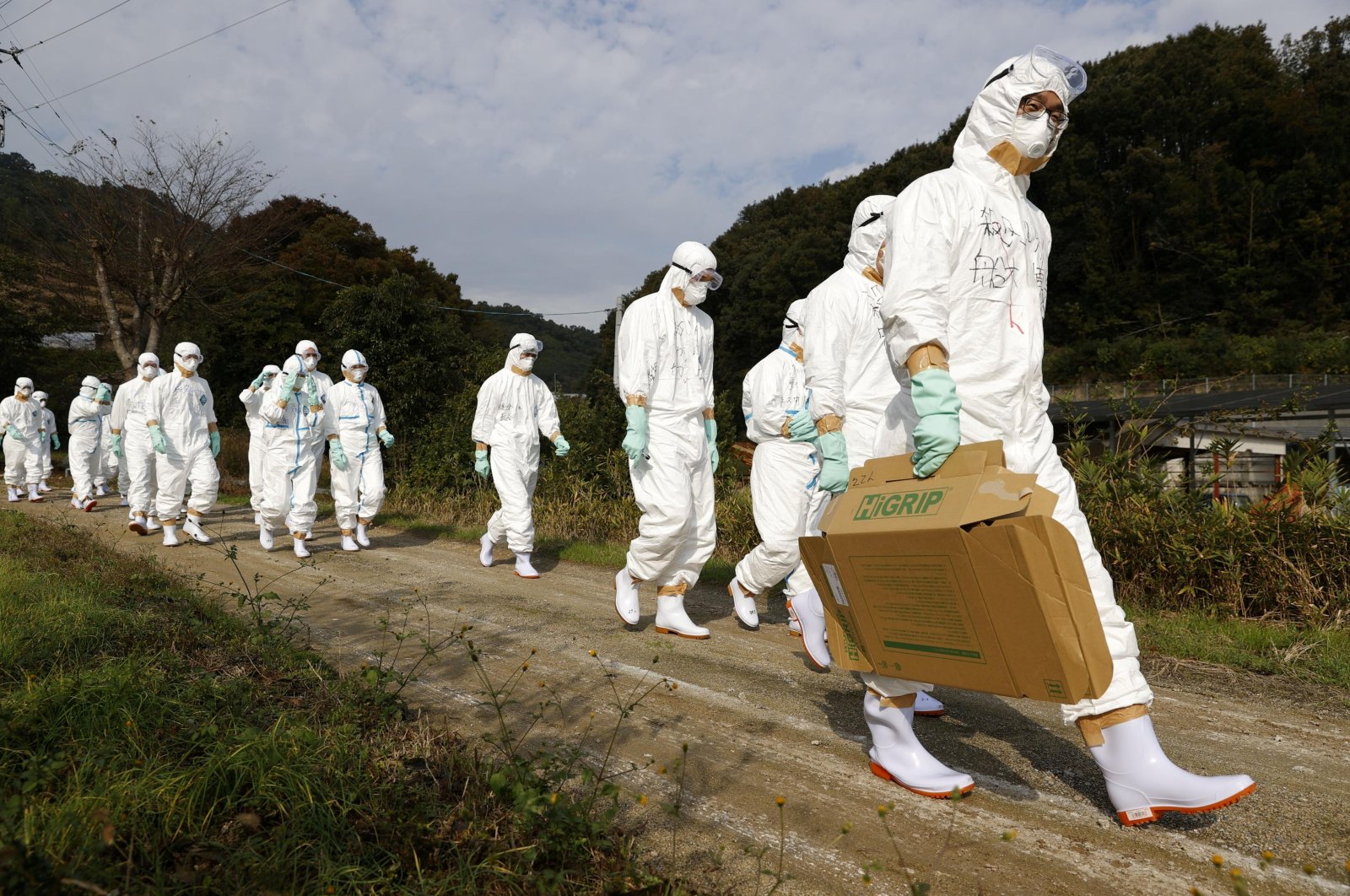 Officials in protective suits head to a poultry farm for a suspected bird flu case in Higashikagawa, western Japan, Nov. 8, 2020. (Kyodo via Reuters)