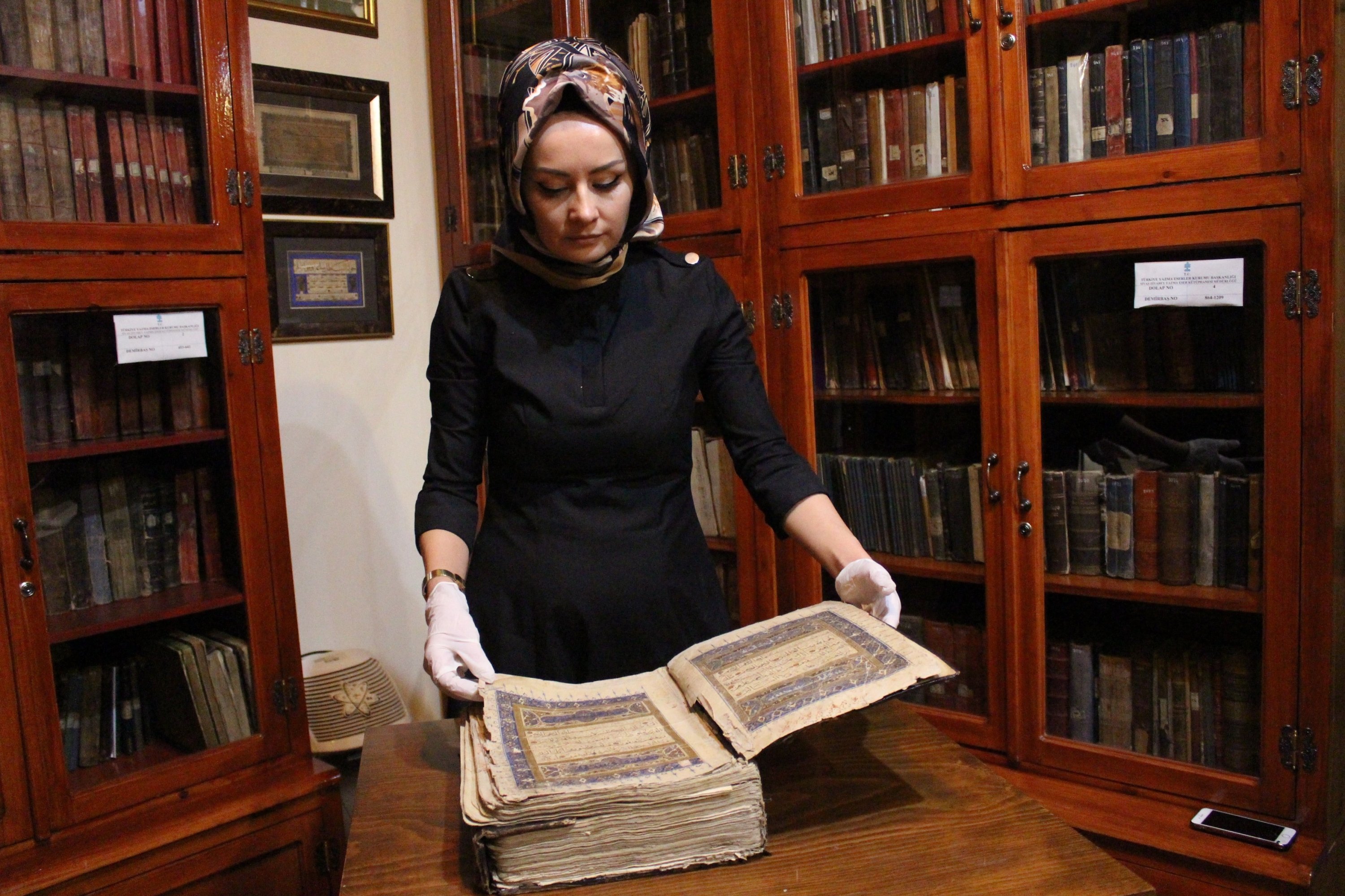 Director of Sivas Ziya Bey Manuscripts Library Dahiye Karagülle displaying the six-century-old handwritten Quran at the library in the central city of Sivas, Turkey, Nov. 15, 2021. (IHA Photo)