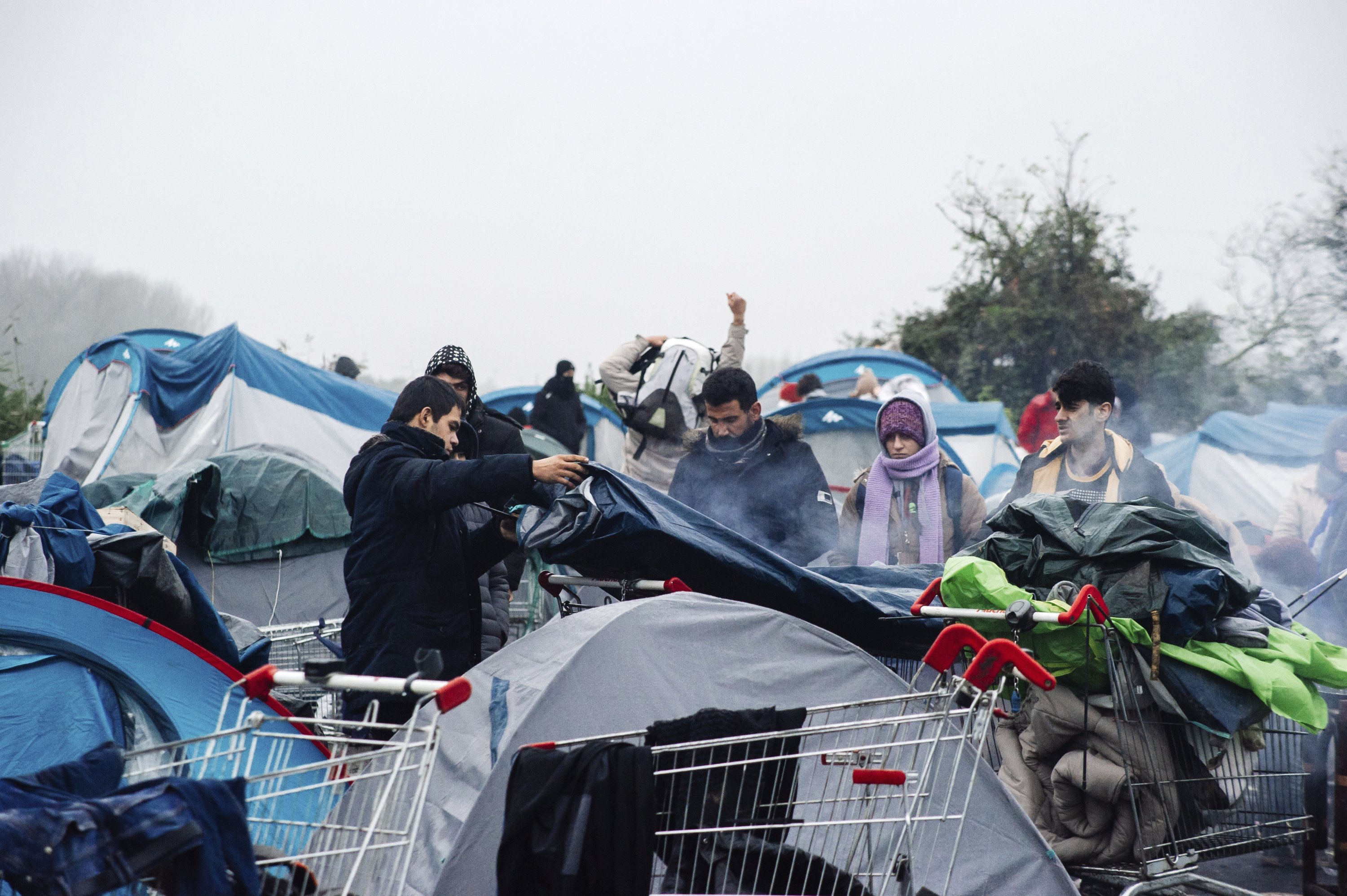Migrants pack their belongings in a camp in Grande-Synthe, northern France, Nov. 16, 2021. (AP Photo)