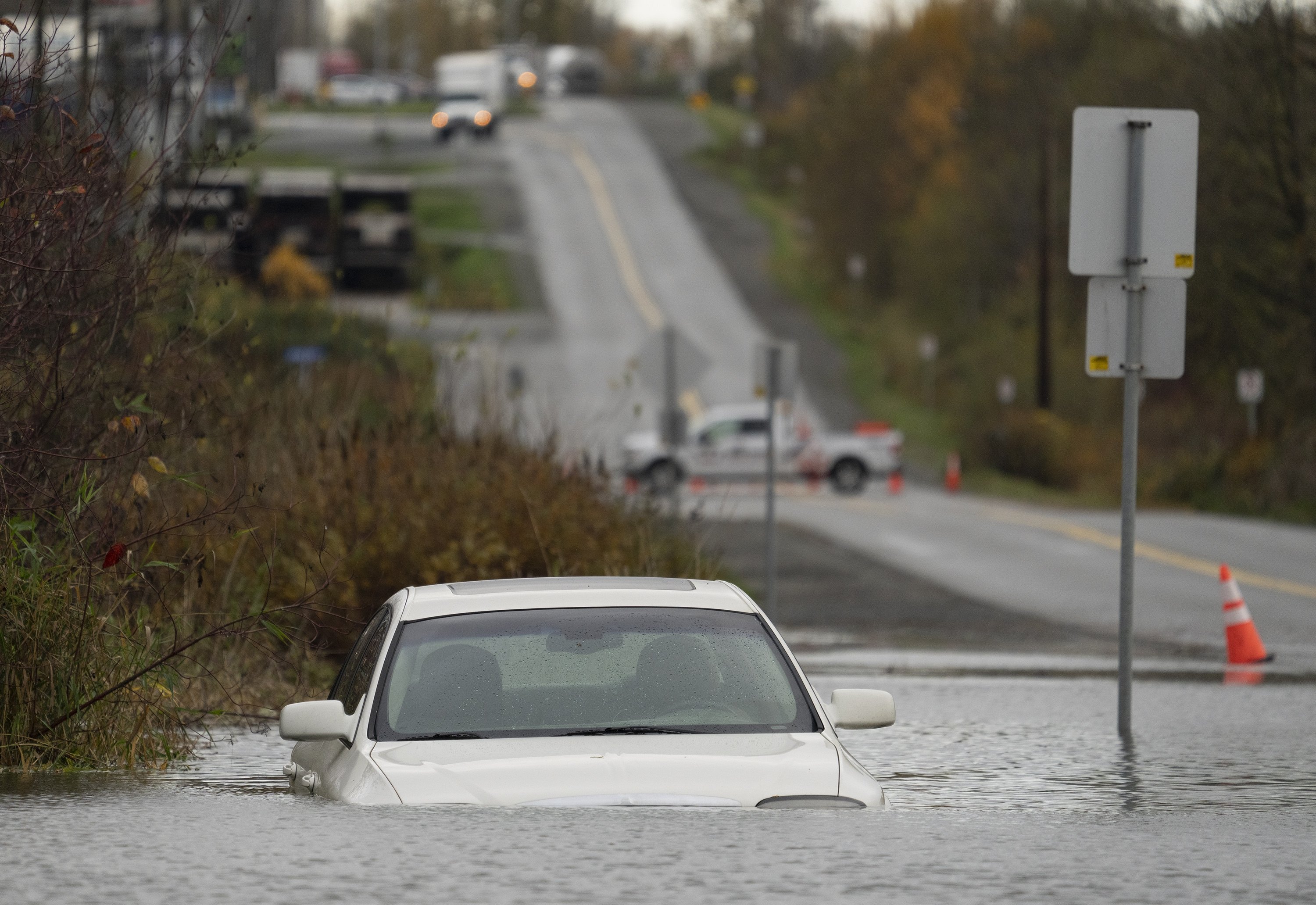 A vehicle is submerged in flood waters along a road in Abbotsford, British Columbia, Monday, Nov. 15, 2021. (Jonathan Hayward/The Canadian Press via AP)