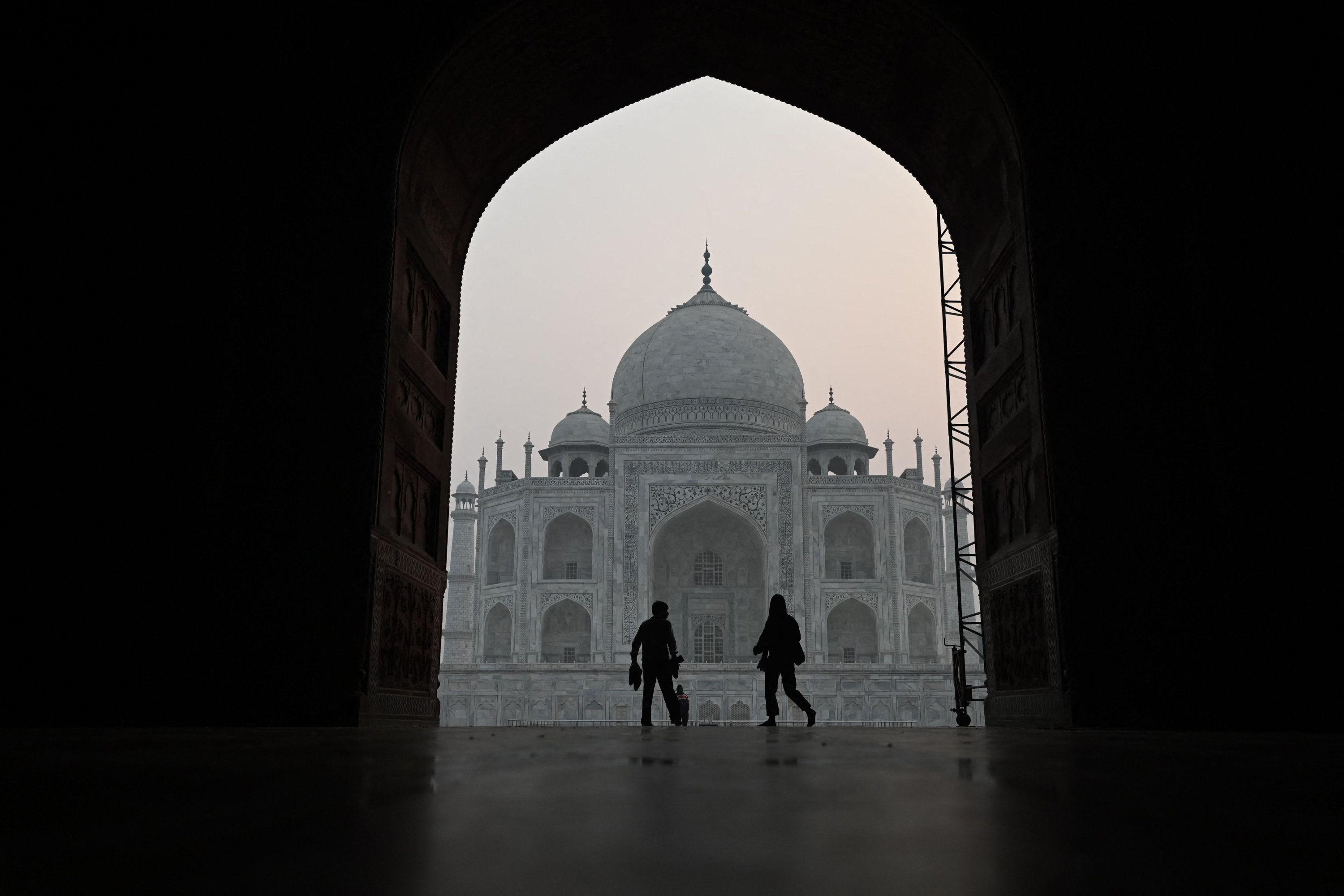 Pengunjung berjalan di dalam Taj Mahal di tengah kondisi kabut asap saat matahari terbit di Agra, India, 16 November 2021. (AFP Photo)