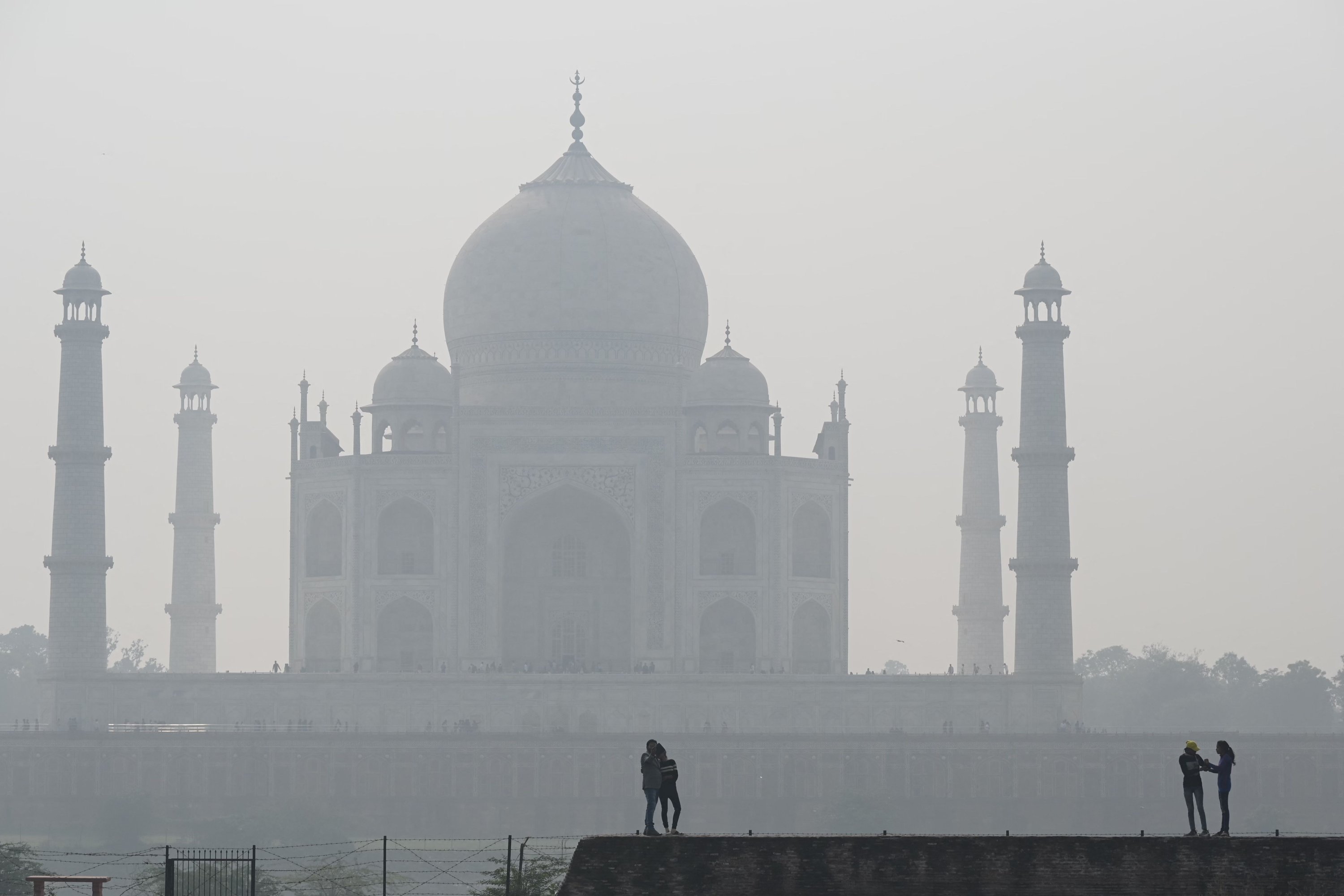 Orang-orang mengunjungi kompleks Mehtab Bagh di belakang Taj Mahal di tengah kondisi kabut asap di Agra, India, 16 November 2021. (AFP Photo)
