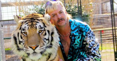 Joseph "Joe Exotic" Maldonado-Passage poses with one of his tigers, Jan. 20, 2020. (AFP File Photo via Netflix US) 