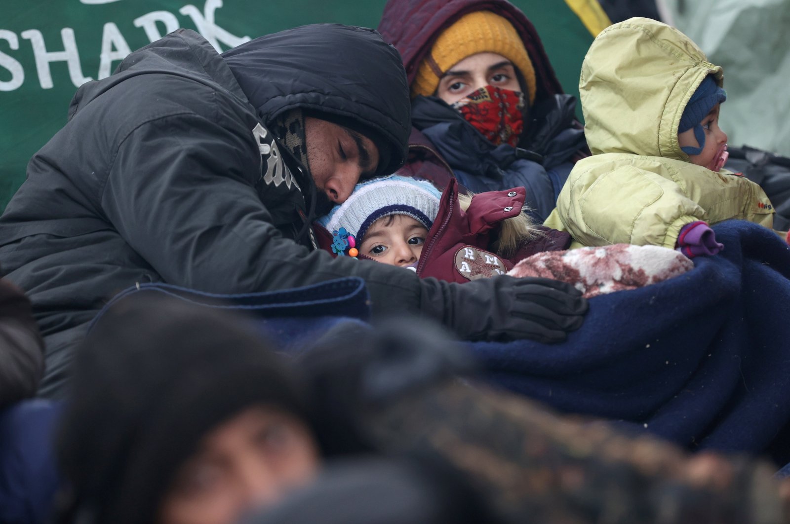 Migrants rest next to a tent set up at the Bruzgi-Kuznica Bialostocka border crossing in the Grodno Region, Belarus, Nov. 15, 2021. (Reuters Photo)