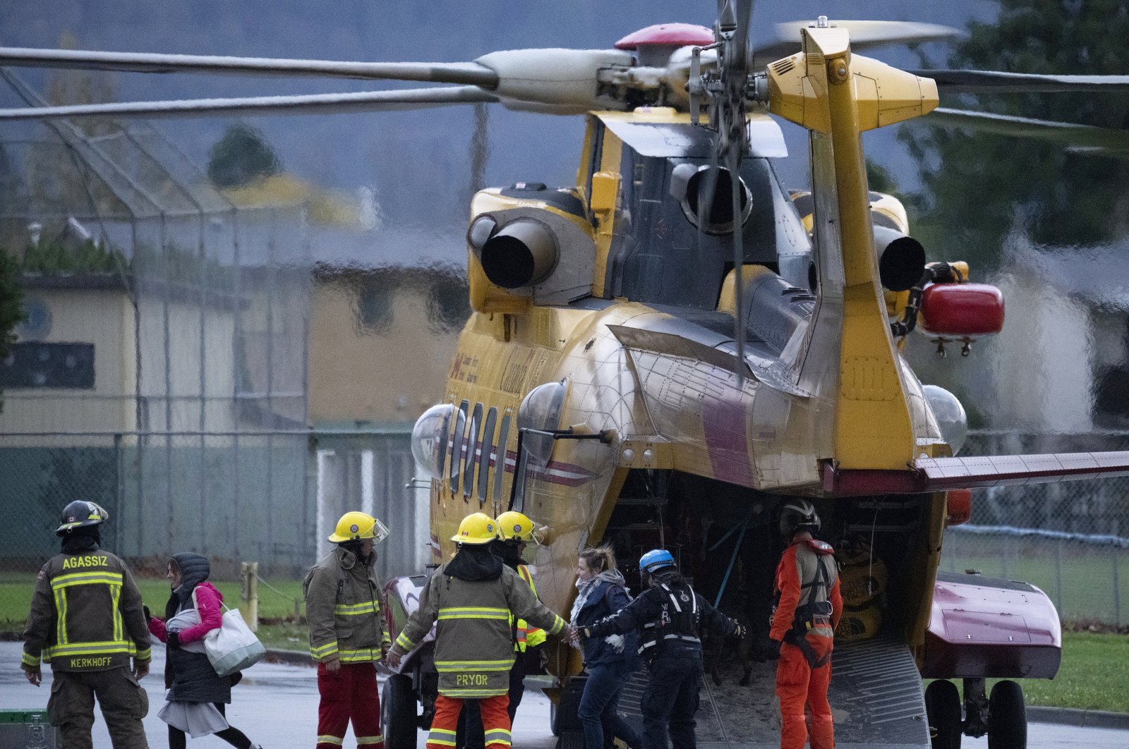 Search and rescue personnel help flood evacuees disembark from a helicopter in Agassiz, British Columbia, Monday, Nov. 15, 2021. (Jonathan Hayward/The Canadian Press via AP)
