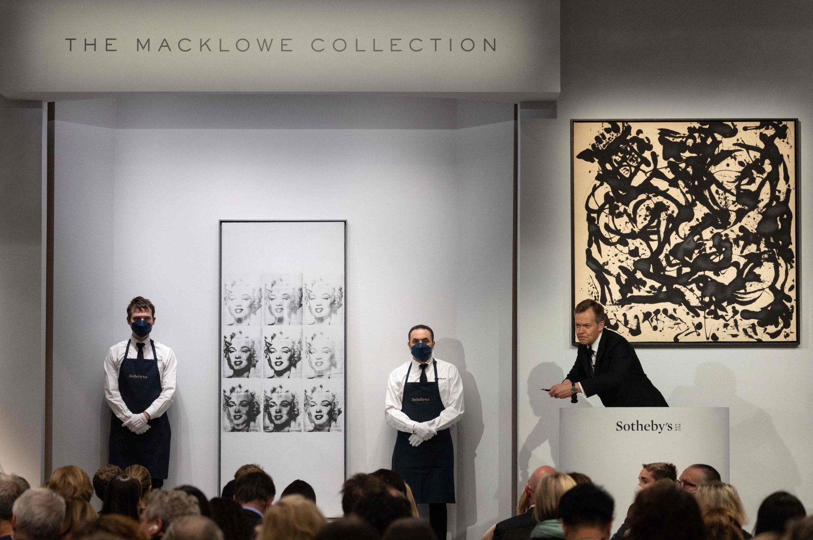 Sotheby&#039;s auctioneer Oliver Barker leads an auction of &quot;The Macklowe Collection,&quot; alongside Andy Warhol&#039;s &quot;Nine Marilyns&quot; (L) sold for $47,373,000 and Jackson Pollock&#039;s &quot;Number 17, 1951&quot; (R), at Sotheby&#039;s in New York City, U.S., Nov. 15, 2021. (AFP Photo)