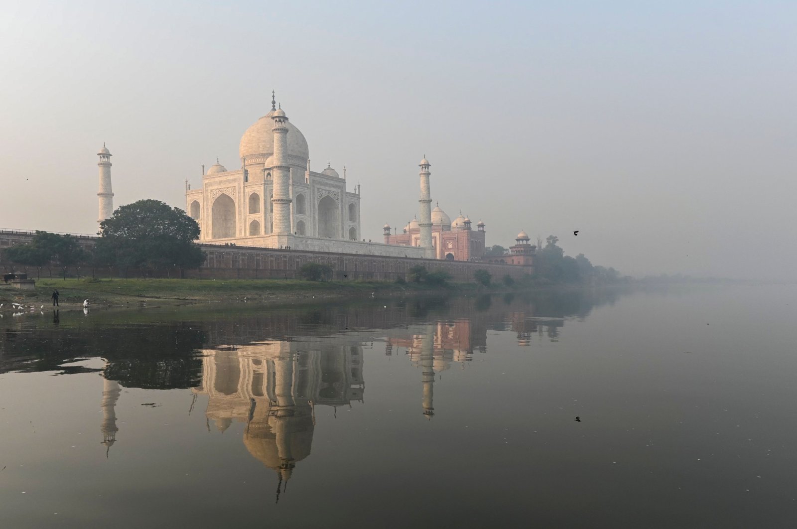 Men pray at the banks of the Yamuna River near the Taj Mahal amid smoggy conditions in Agra, India, Nov. 16, 2021. (AFP Photo)