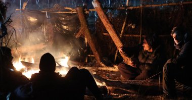Migrants aiming to cross into Poland warm themselves by a fire on the Belarusian-Polish border in the Grodno region, Belarus, Nov. 16, 2021. (AFP Photo)