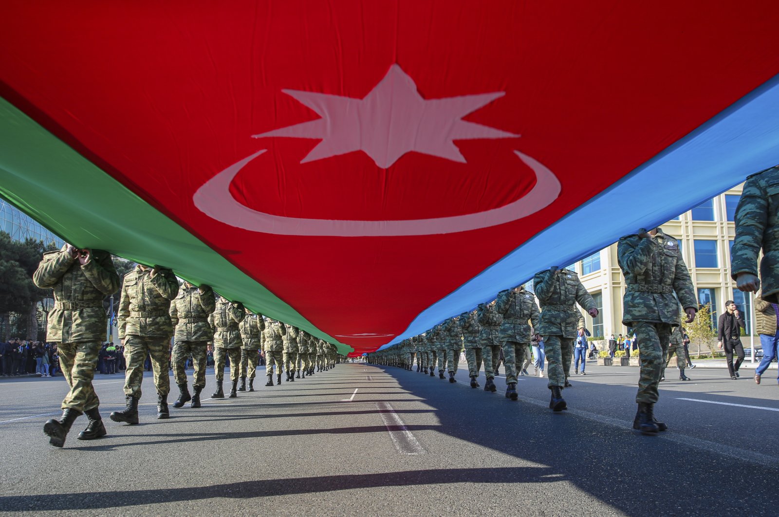 Azerbaijani soldiers carry a large-scale national flag on the anniversary of the end of the 2020 war over the Nagorno-Karabakh region between Azerbaijan and Armenia, in downtown Baku, Azerbaijan, Nov. 8, 2021. (EPA Photo)