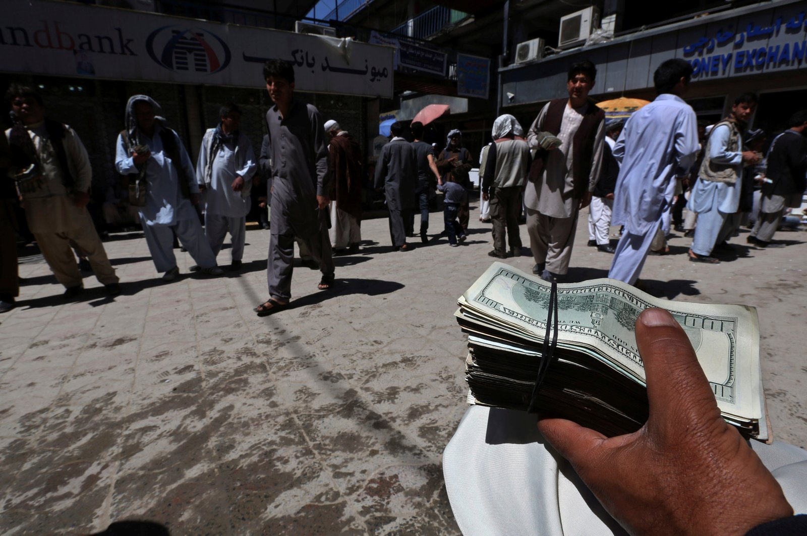 A money exchanger holds a stack of U.S. dollars at Kabul&#039;s largest money market, Afghanistan, April 23, 2014. (Reuters Photo)