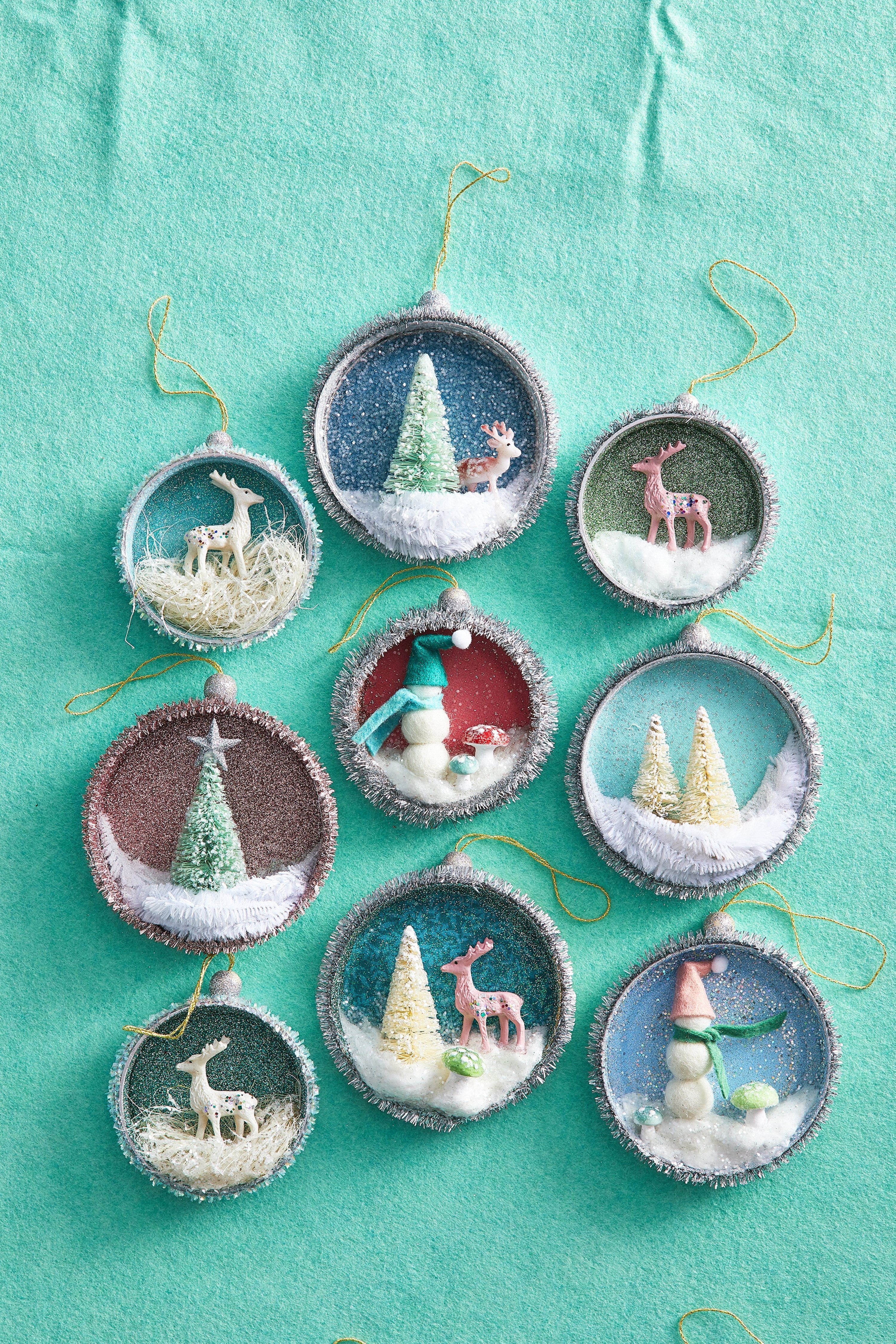 This image provided by Better Homes & Gardens shows diorama ornaments made out of upcycled Mason jar lids. (Carson Downing/Better Homes & Gardens via AP)