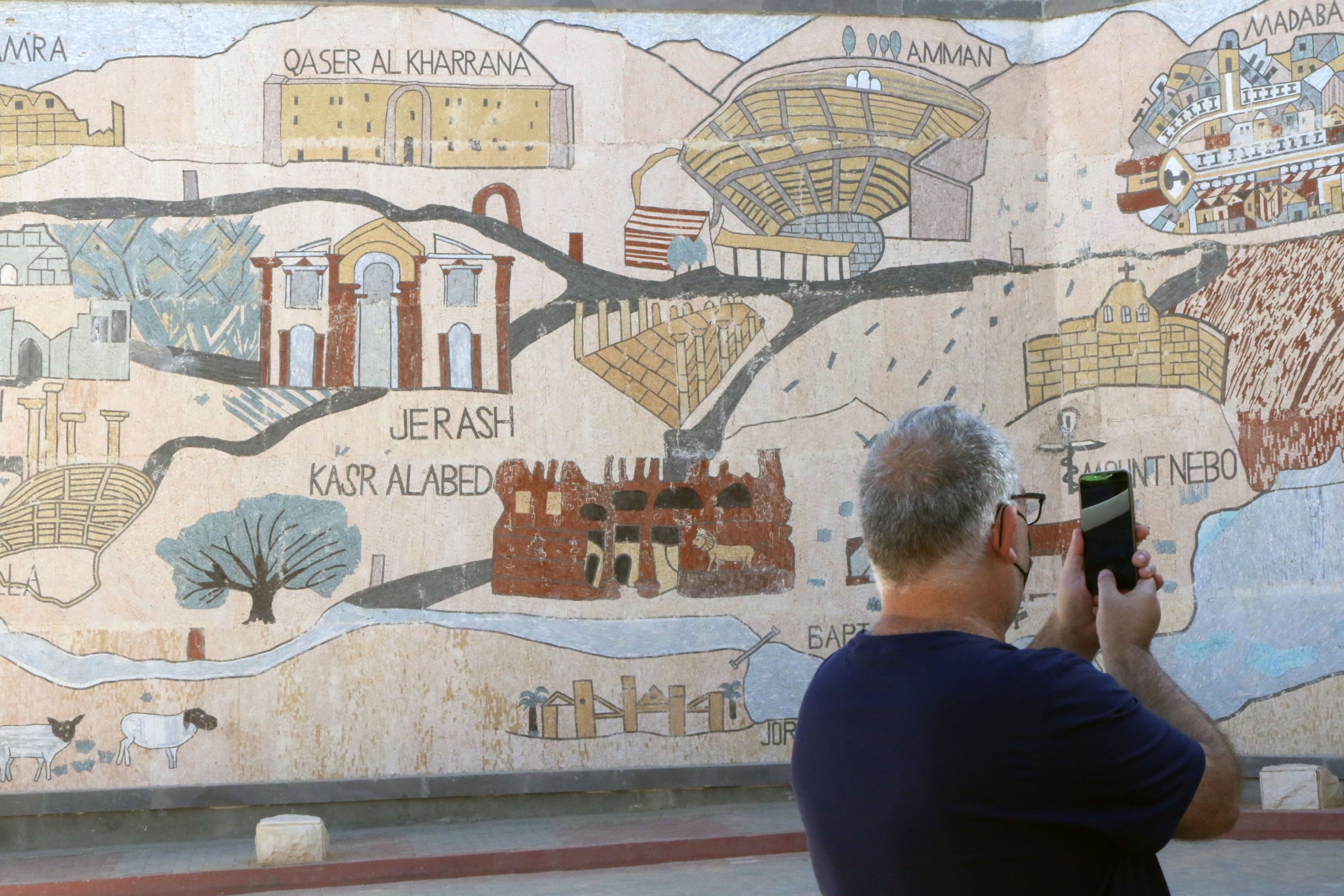 A visitor takes pictures of the largest mosaic in the world, placed on a large wall in Madaba, southwest of capital Amman, Jordan, Nov. 17, 2021. (AA Photo)