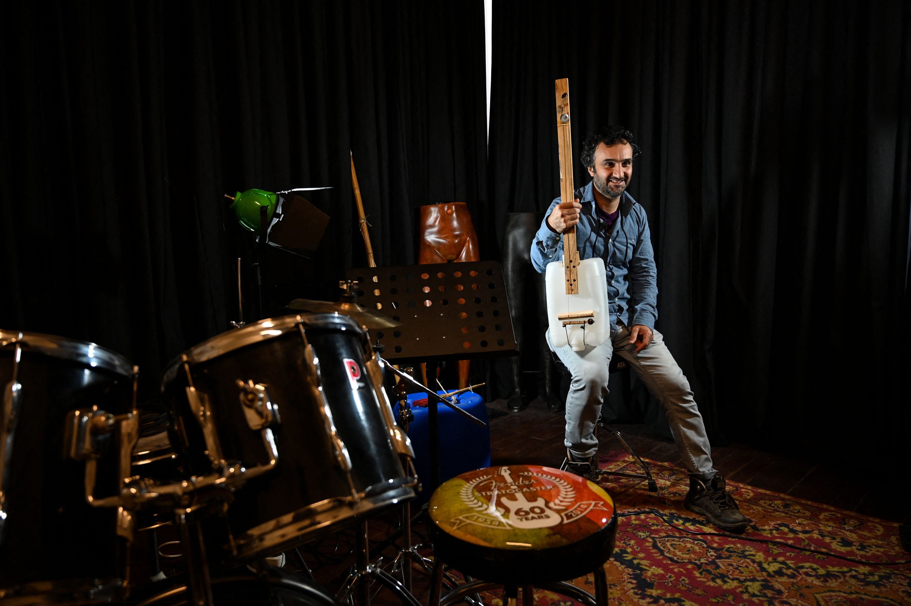 Anggota band Fungistanbul Roni Aran berpose saat dia bersiap untuk tampil dengan salah satu instrumennya yang dibuat dengan sampah di Istanbul, Turki, 8 November 2021. (AFP Photo)