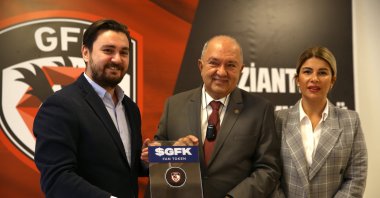 Socios.Com Turkey director Altuğ Öztürk (L) presents a symbolic fan token to Gaziantepspor chairperson Cevdet Akınal (C) after the company signs a fan token deal with Süper Lig team, in Gaziantep, southern Turkey, Nov. 17, 2021. (AA PHOTO)